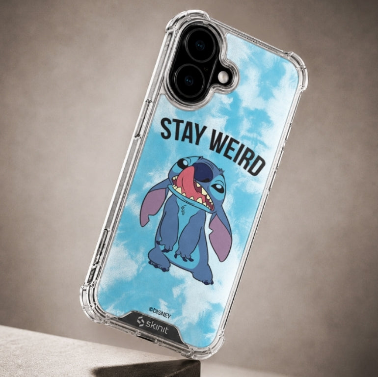 A clear protective phone case with a printed graphic of Stitch on a blue cloudy background with the text 'STAY WEIRD'. The case is shown on a smartphone, photographed against a neutral textured gray background.